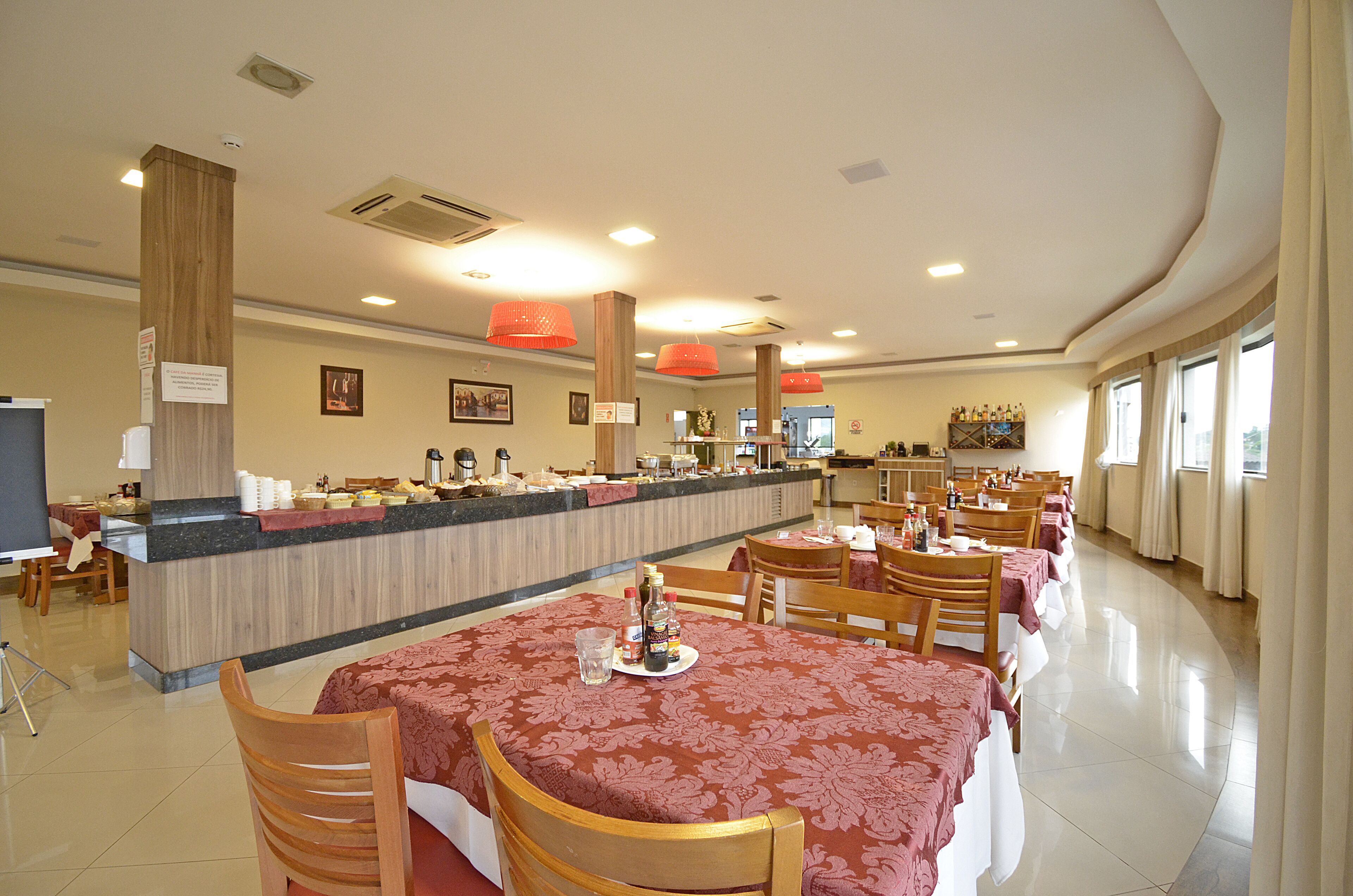 Un grand espace dédié à la salle à manger, avec un long comptoir, plusieurs tables et des chaises.