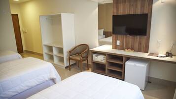 Habitación de hotel con dos camas, un escritorio, una silla, un televisor y un minibar.