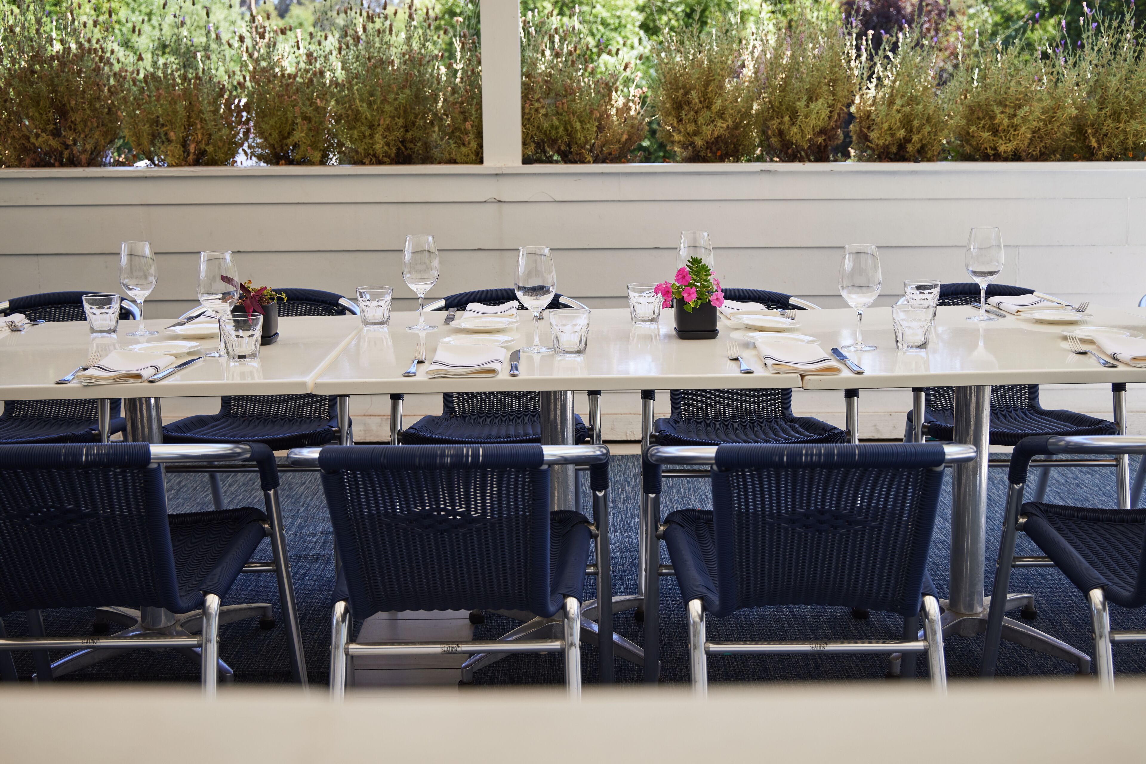 A conference table set for a meeting with chairs around it.