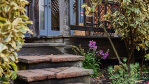 A stone staircase leading to a wooden deck with a lattice fence.