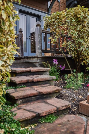 A stone staircase leading to a wooden deck with a lattice fence.
