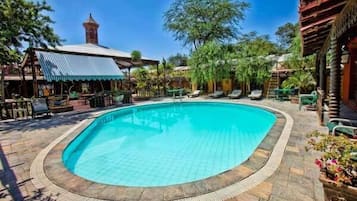 Una piscina al aire libre, sillones reclinables de piscina