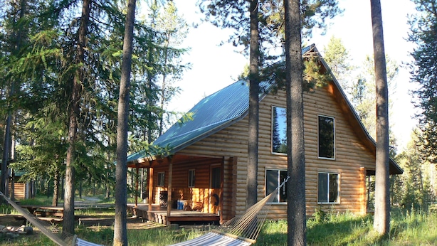 A log cabin with a porch and a hammock. - Smoky Bear Ranch Bed & Breakfast & Cabins (Columbia Falls)