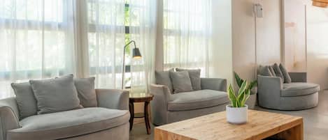 A modern living room with two sofas, a wooden coffee table, and a floor lamp.