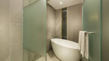 A modern bathroom with a freestanding bathtub, glass shower enclosure, and a towel rack.