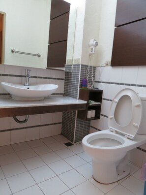 A bathroom with a white sink, a toilet, and a mirror. - Quan Fu Tan Hui Hotel (Yuchi)