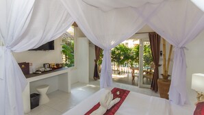 A hotel room with a bed, a desk, and a TV. - The White Cottage (Koh Samui)