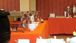 Un'attrezzatura per buffet con diverse postazioni di servizio, tra cui un'ampia scelta di ciotole e piatti.