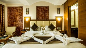 Habitación de hotel con cama, una silla, un escritorio y una pared con diseño texturizado.