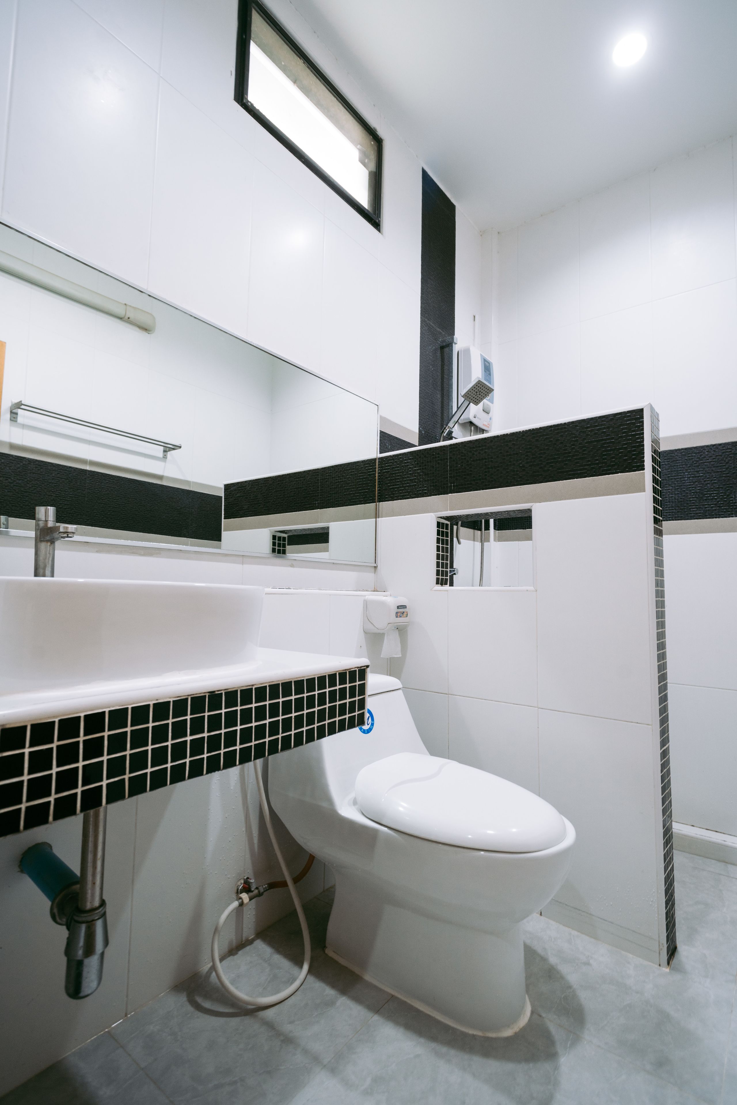 Un baño moderno con lavamanos blanco, inodoro y zona de ducha.