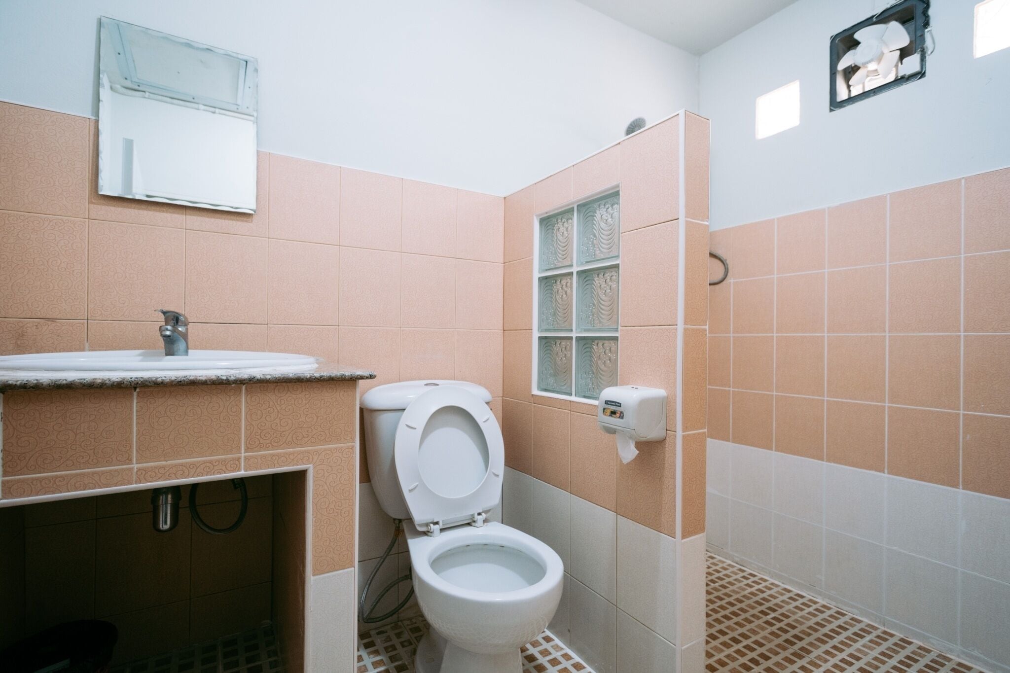 Ein Badezimmer mit Toilette, Waschbecken und Spiegel.