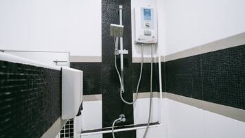 Ein Badezimmer mit schwarz-weißer Fliesenwand, einer weißen Duschkabine und einem Bedienfeld.