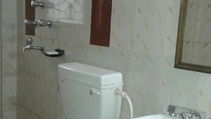 A bathroom with a toilet, sink, and mirror. - Simurg- AK50 New Town (Barasat)