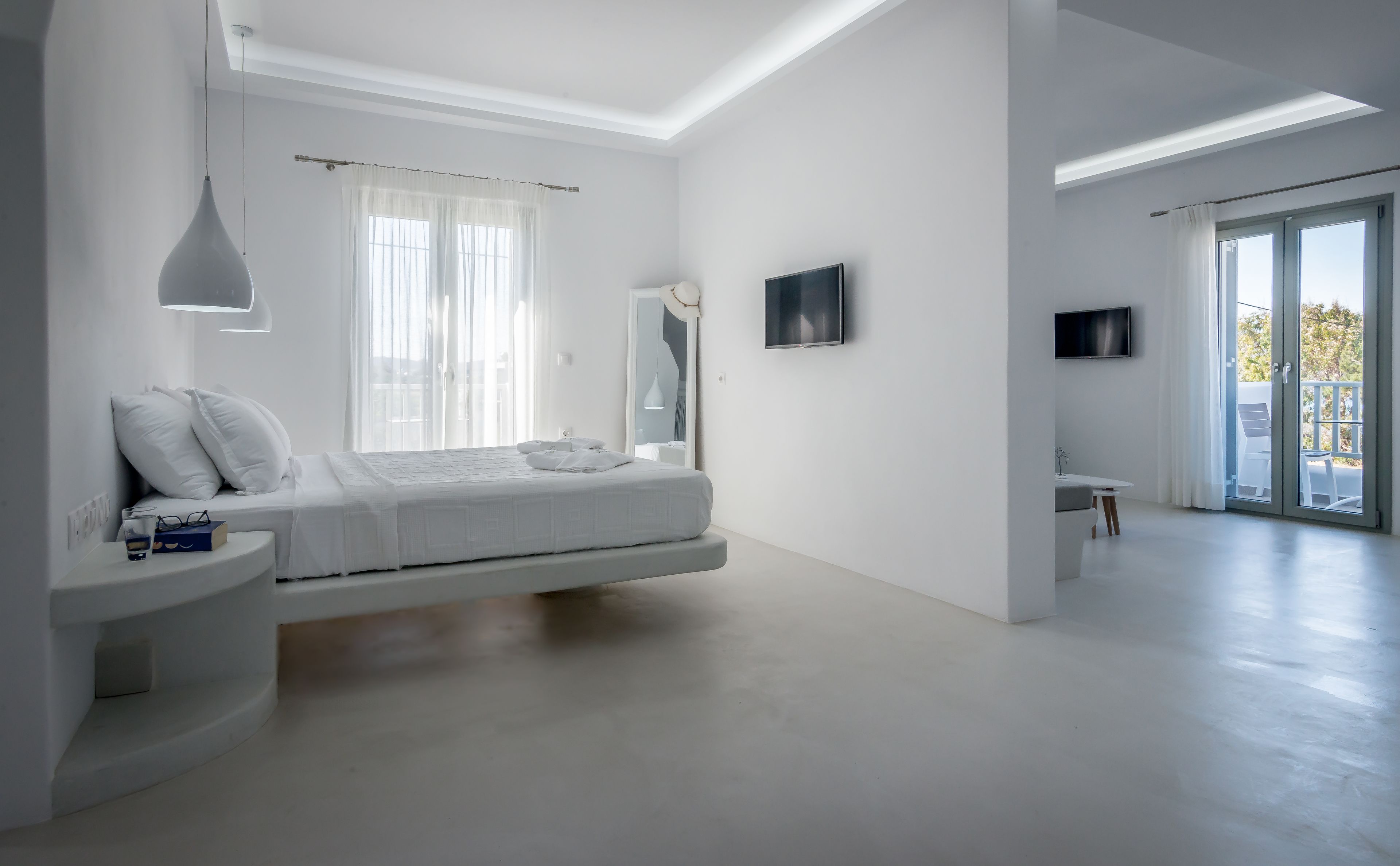 A modern bedroom with a bed, bedside table, and a TV.