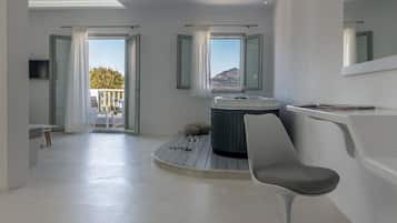 Relax in a spacious room with a curved seating area, hot tub, and flat-screen TV.