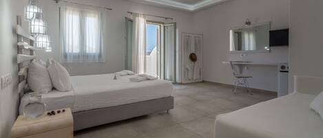A modern hotel room with a large bed, a bedside table, a chair, a TV, and a bathroom with a shower and toilet.