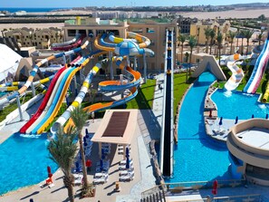 Ein Wasserpark mit mehreren Rutschen und Pools, umgeben von Gebäuden.