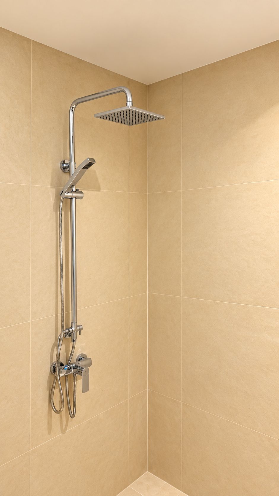 A shower with a handheld showerhead and a wall-mounted control panel.