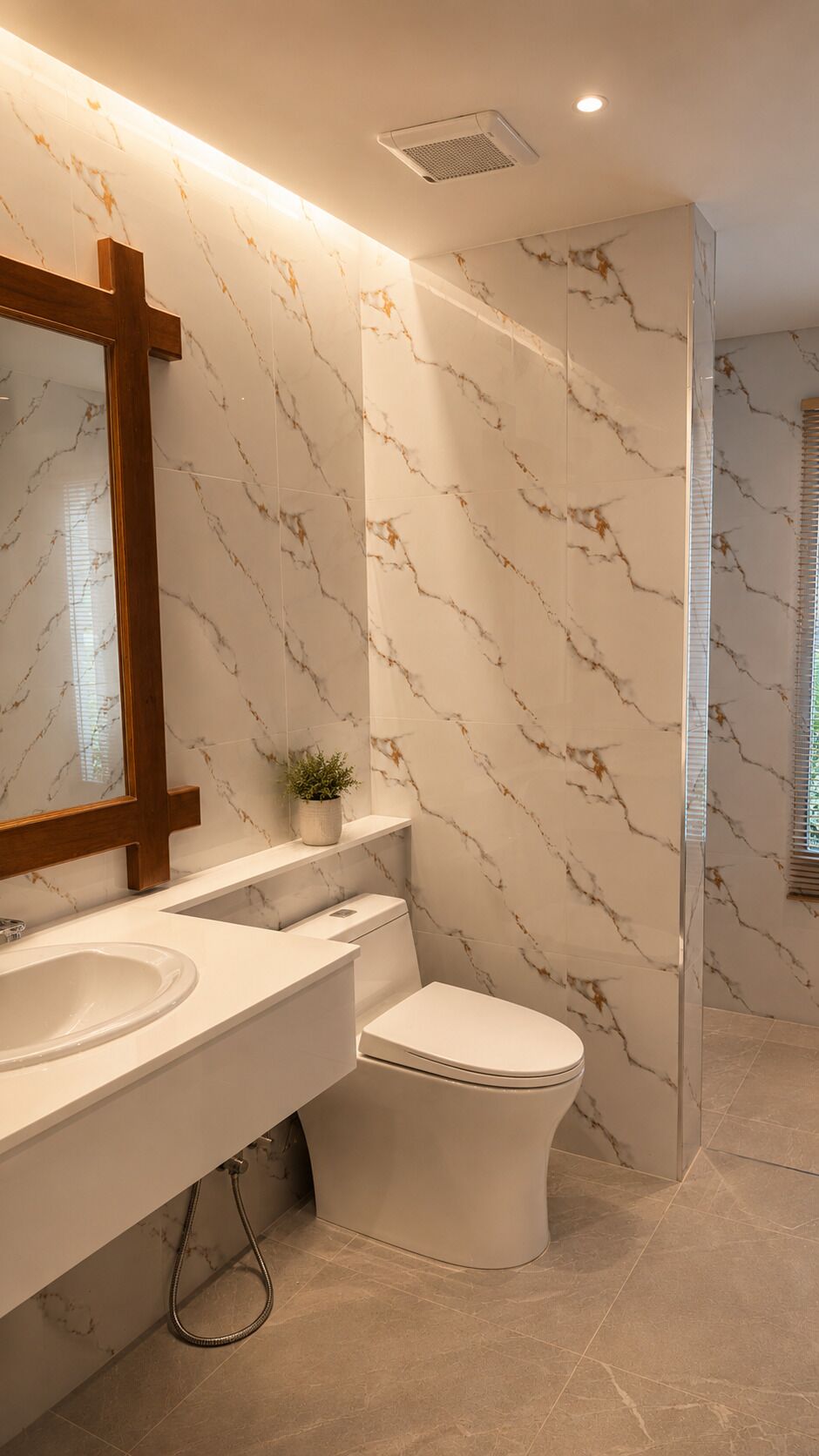 Ein modernes Badezimmer mit Marmorfliesenspiegel, einem spiegel mit Holzrahmen, einem weißen Waschbecken und einer Toilette.