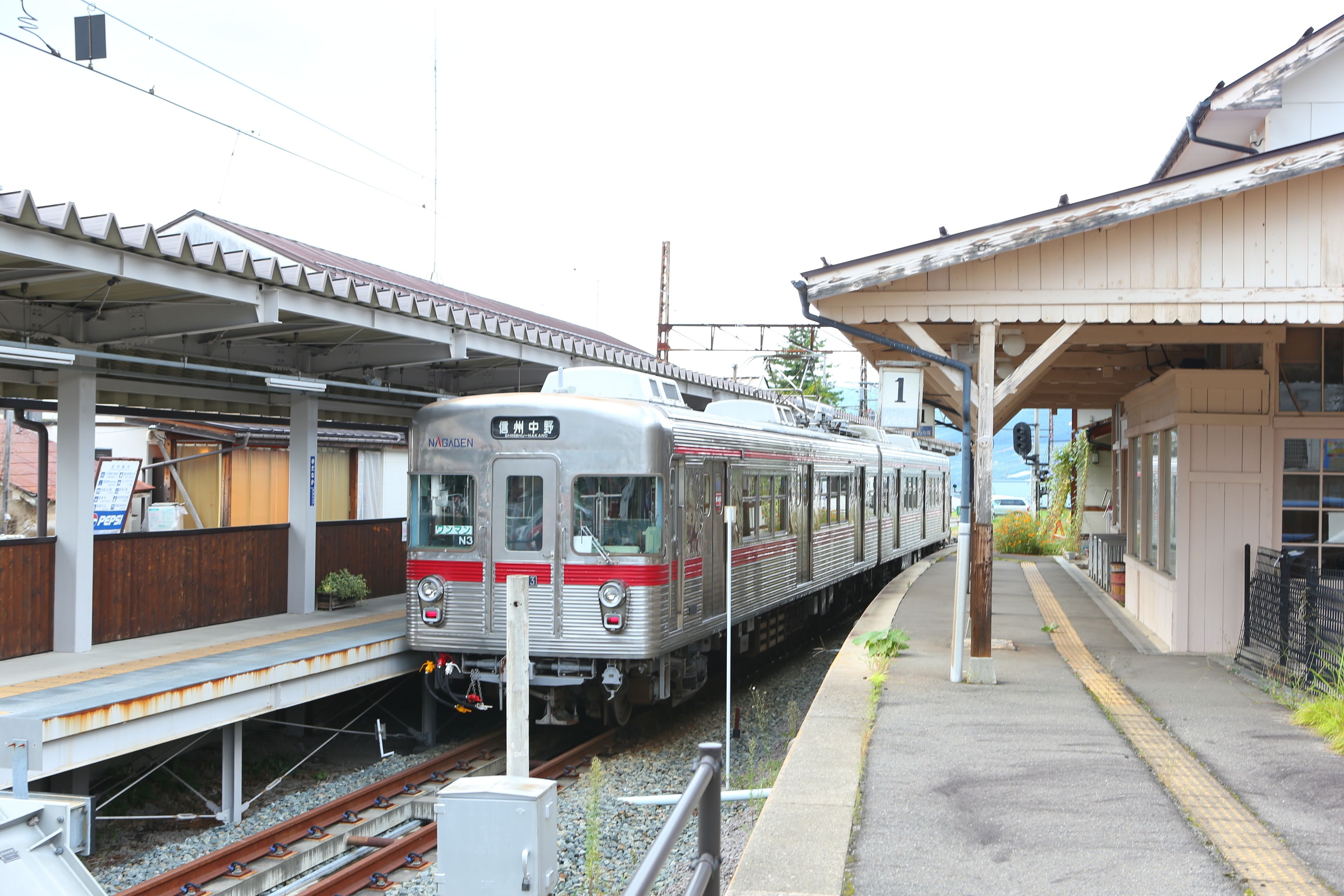 A train station platform with a stationary train.