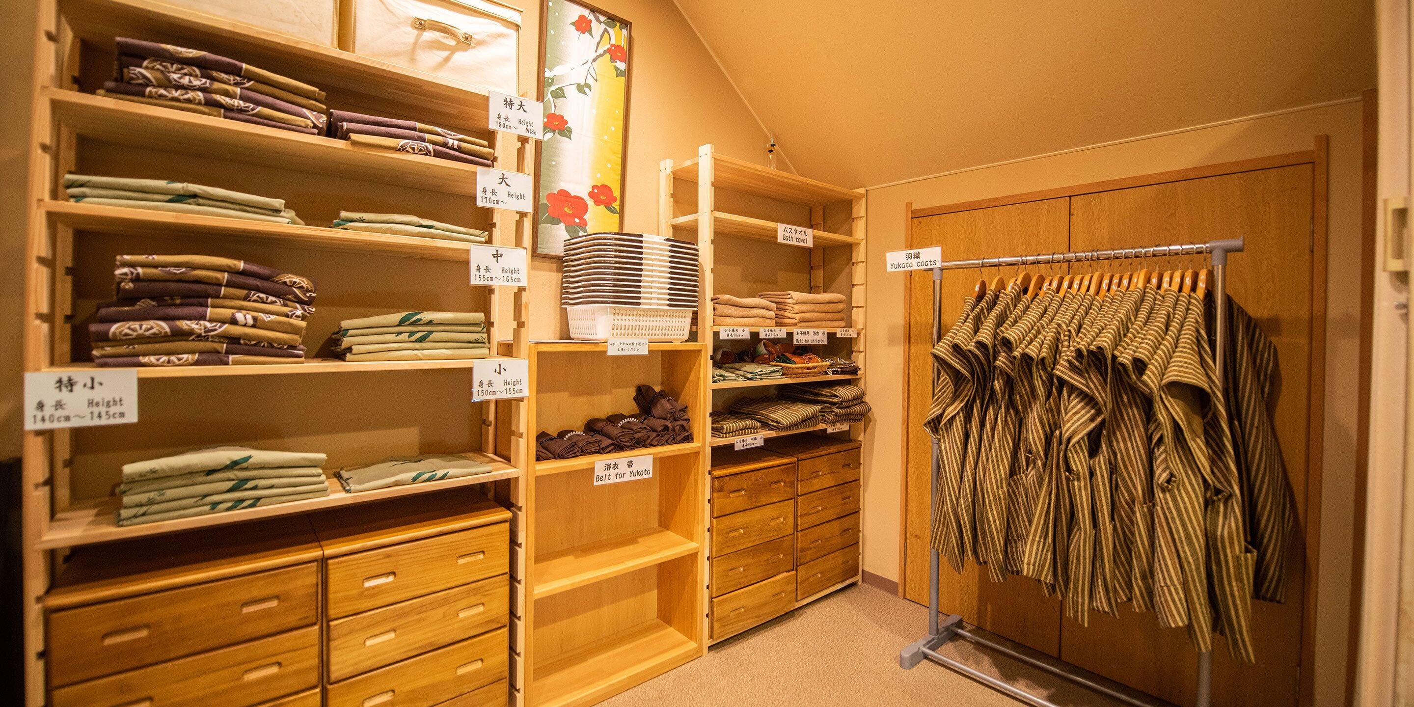 Una tienda de ropa con estantes y perchas ordenadas, llenas de prendas dobladas.