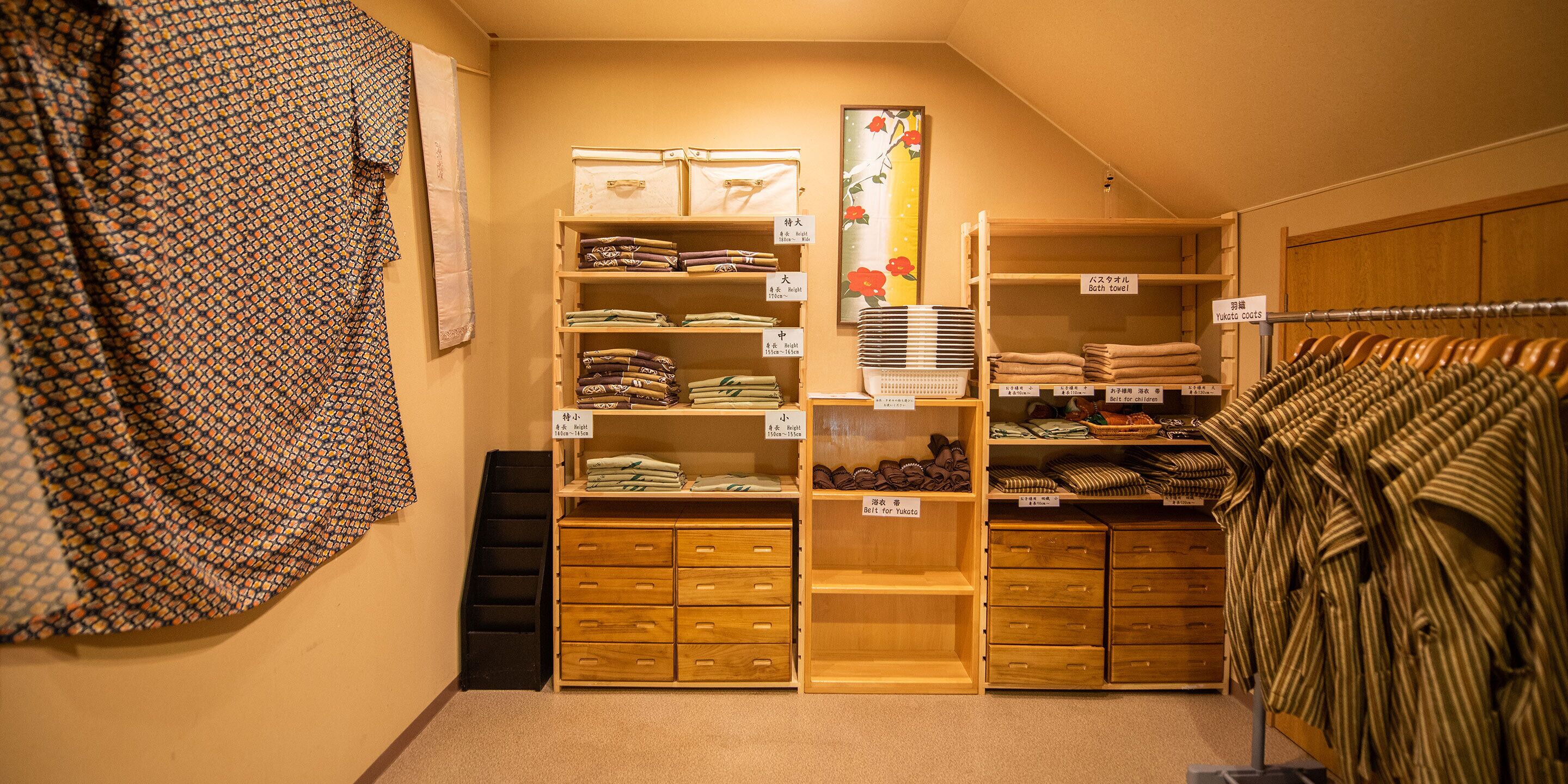 A storage room with neatly organized shelves and drawers containing various textiles, including towels and belts.