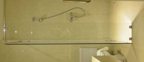 A bathroom with a glass shower enclosure, a towel rack, and a toilet.