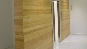 Een modern interieur met een houten paneelwand en een metalen deur.