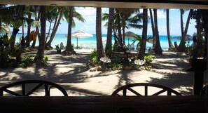 A beach view with palm trees, a sign reading "DEPARTIS RESORT", and a sandy area with chairs and umbrellas.