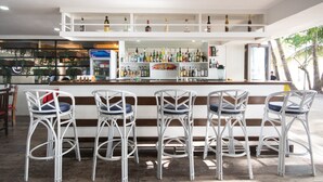 A bar area with white wicker chairs and a bar counter stocked with various bottles. - Deparis Beach Resort (Boracay Island)