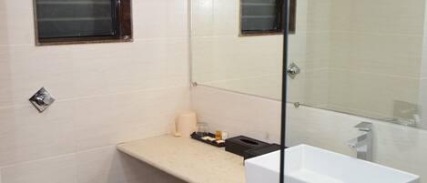 Un baño con inodoro blanco, lavamanos y espejo.