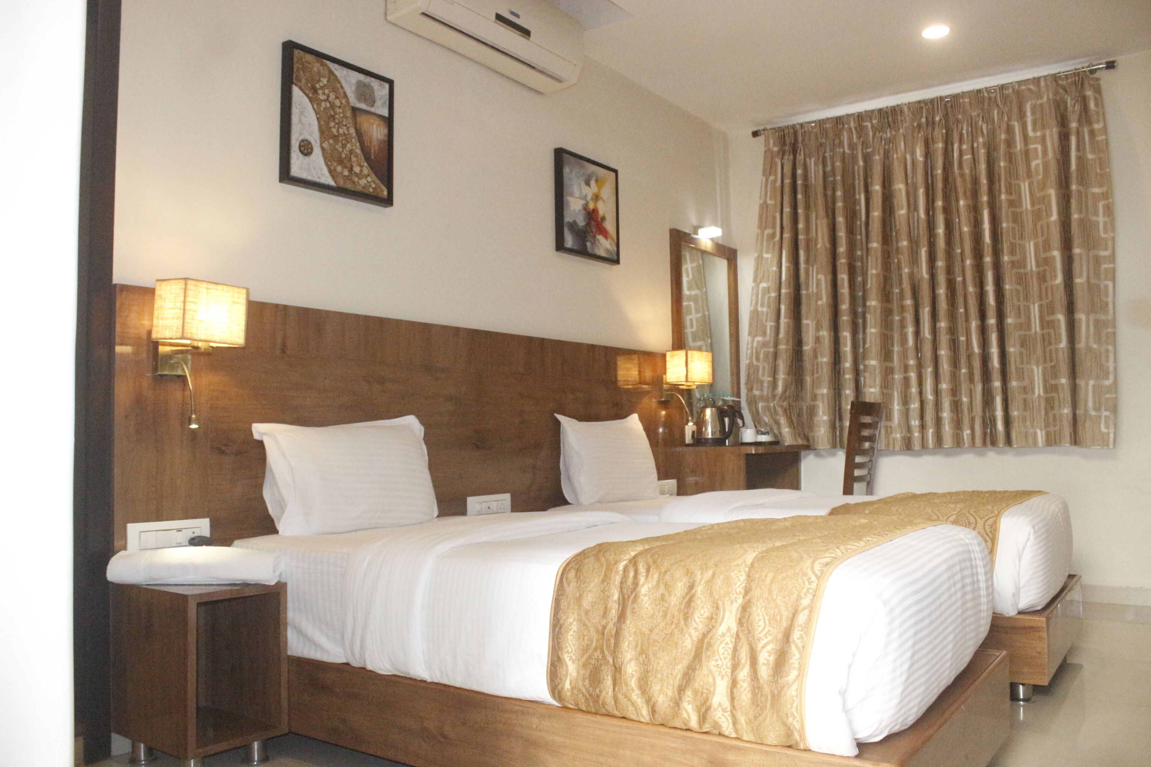 A double bed with a wooden headboard, two bedside lamps, and a large mirror on the wall.