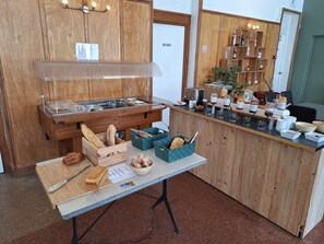 Una kitchenette con una exhibición de pan, una cafetera y diversos alimentos.