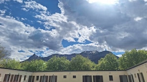 Un edificio con varias ventanas y una montaña al fondo.