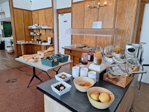 A breakfast buffet setup with various food items and a coffee machine. - Hôtel Le Connetable (Saint-Bonnet-en-Champsaur)