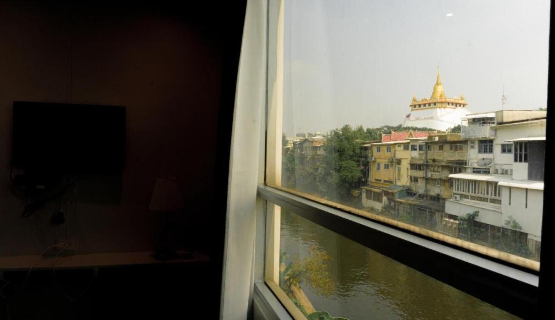 A view of a river with buildings and a golden-domed structure in the distance.