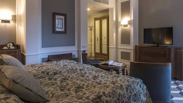 A hotel room with a large bed, a television, a desk, and a chair.