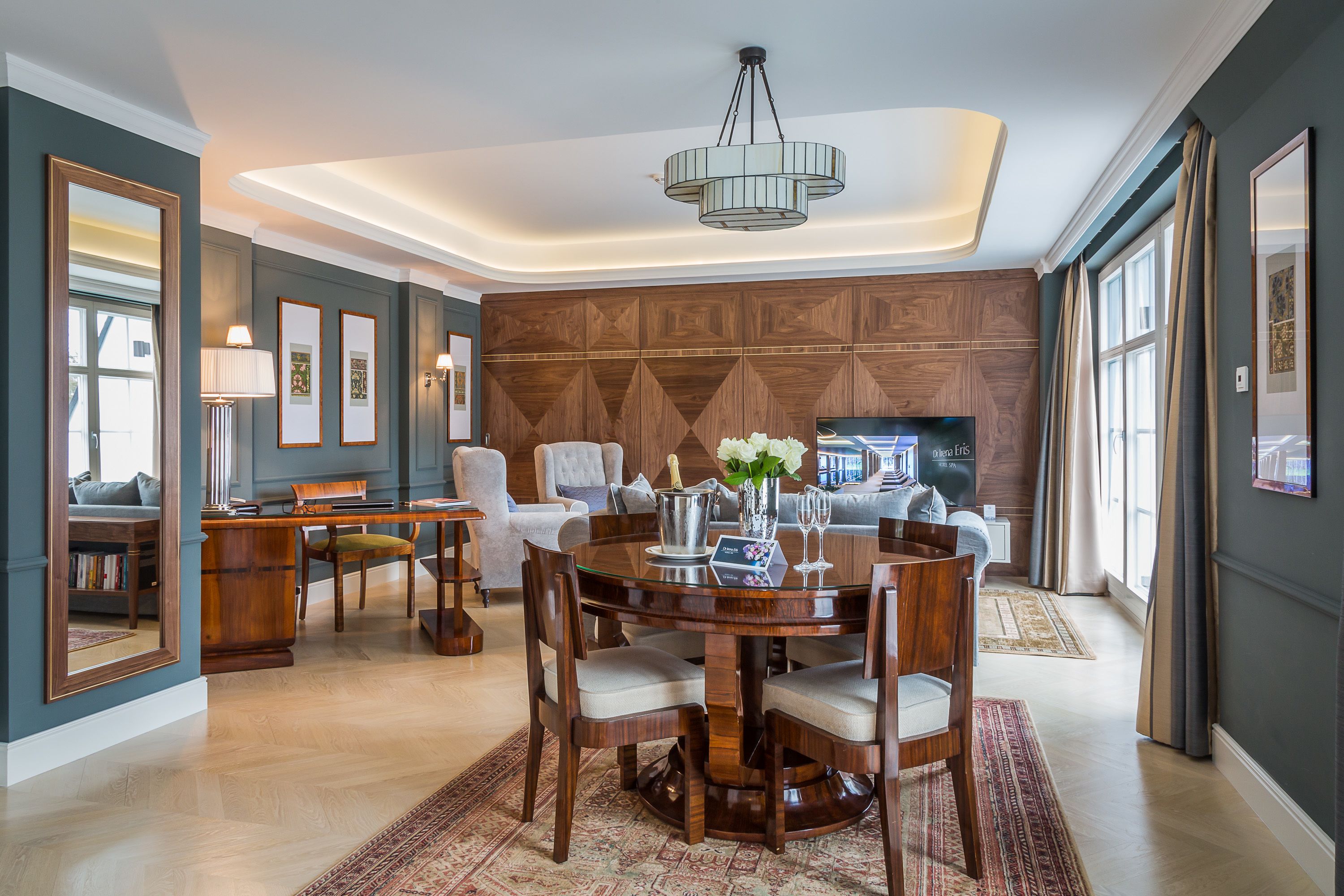 Amplia sala de estar con mesa de comedor de madera, asientos cómodos, chimenea y un ventanal grande.