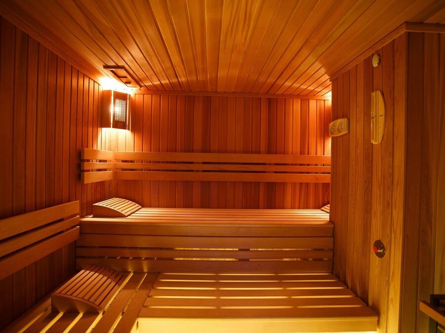 Una sauna de madera con bancos y un asiento.