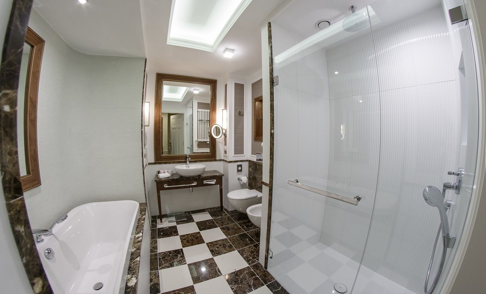 A bathroom with a bathtub, a sink, a toilet, and a glass-enclosed shower.