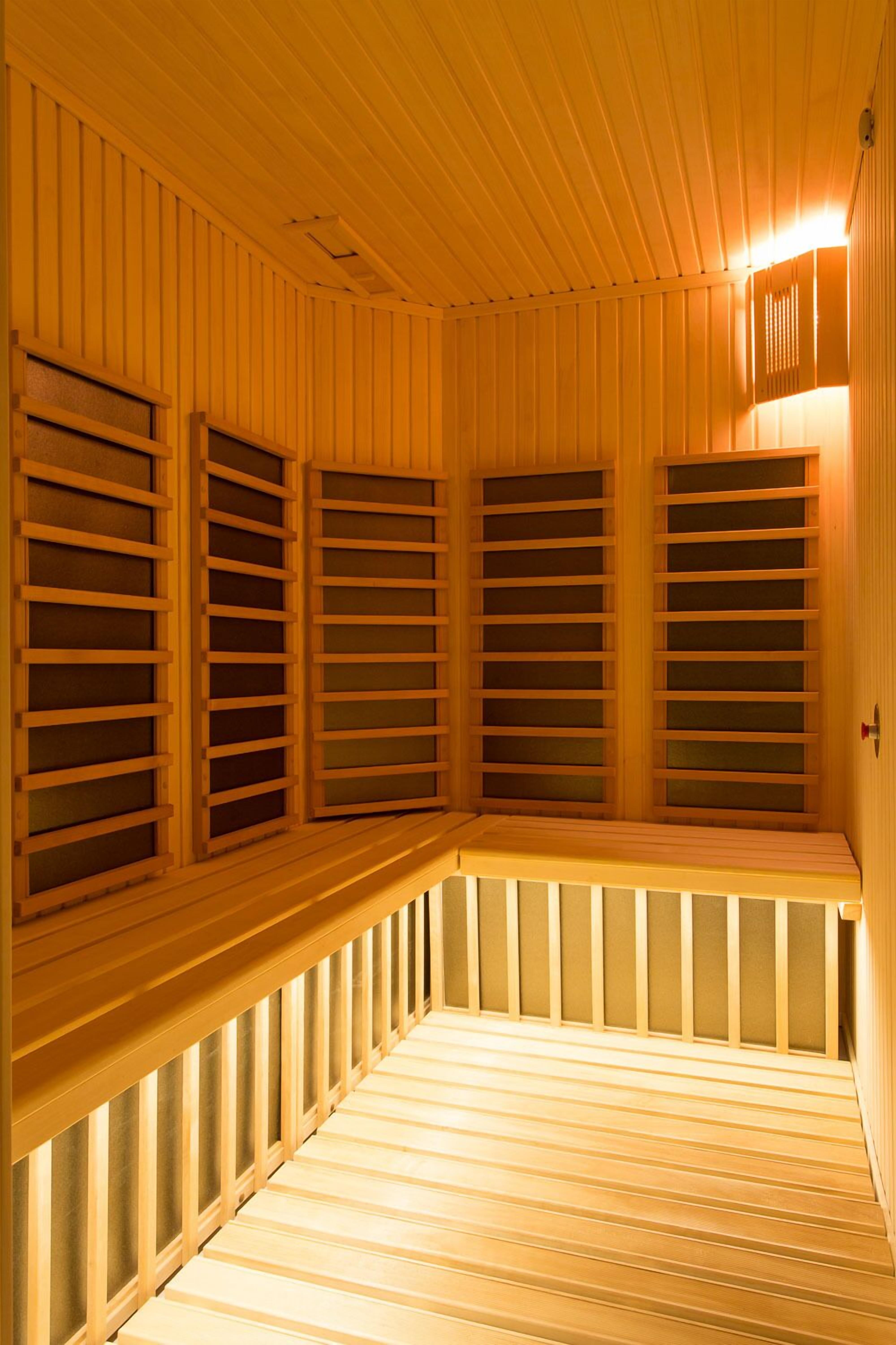 Una sala de sauna con paredes y bancos de listones de madera.