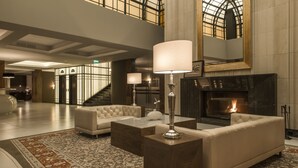 A spacious lobby with a fireplace, leather sofas, and a large rug.