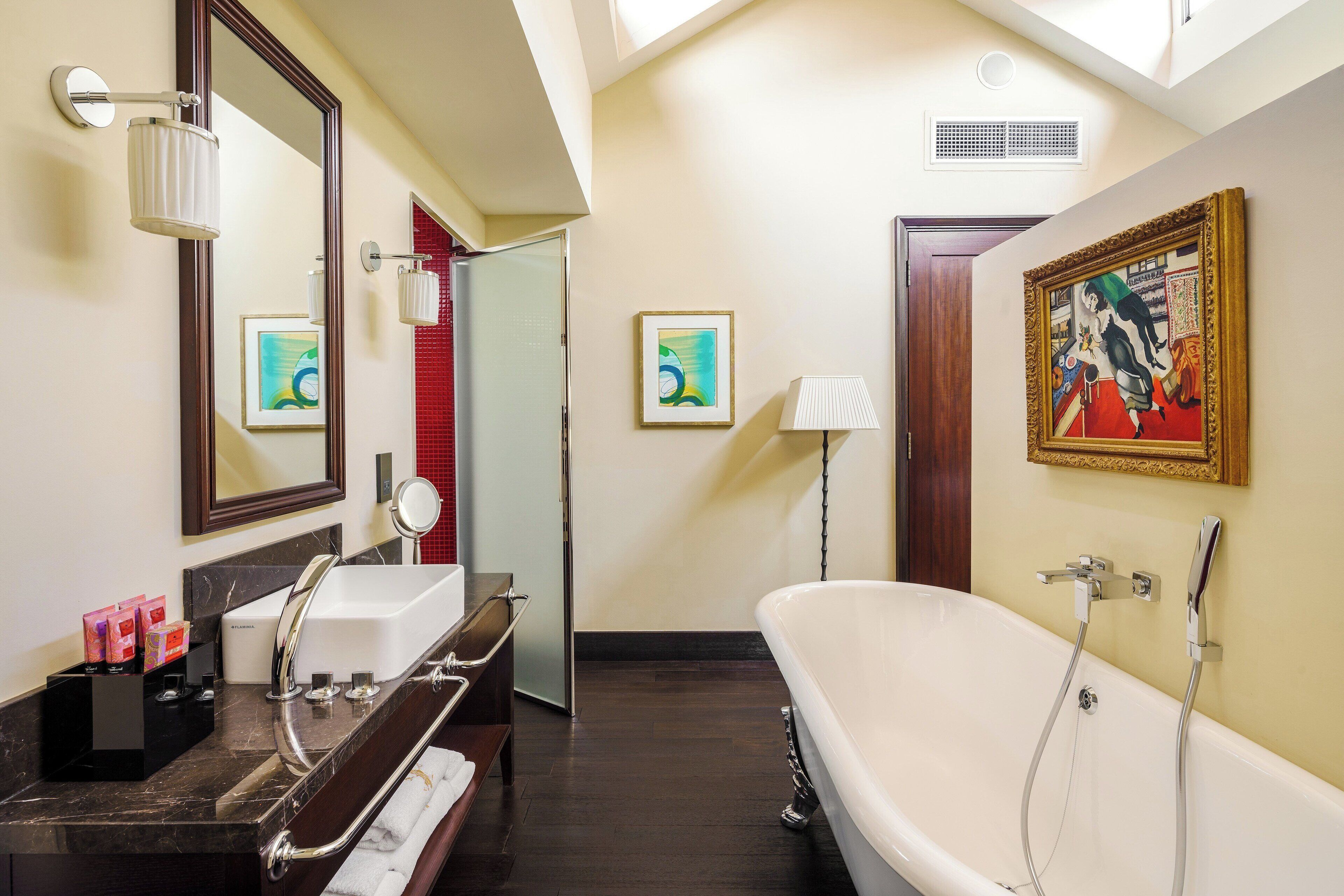 A bathroom with a bathtub, a sink, a mirror, and a towel rack.
