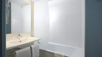 Een moderne badkamer met een wit wastafelmeubel, spiegel en ligbad.