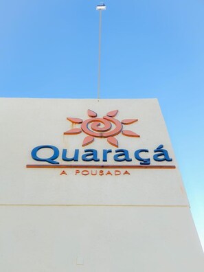 A building with a sign that reads "Quaracá A Fousada" with a stylized sun design above the text. - Quaraçá Pousada (Maceió)