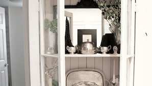 Un armario de cocina blanco con las puertas abiertas, mostrando diversos utensilios y artículos de cocina.