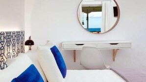 A hotel room with a bed, a bedside table, a mirror, and a view of the sea. - Galatea (Zakynthos)