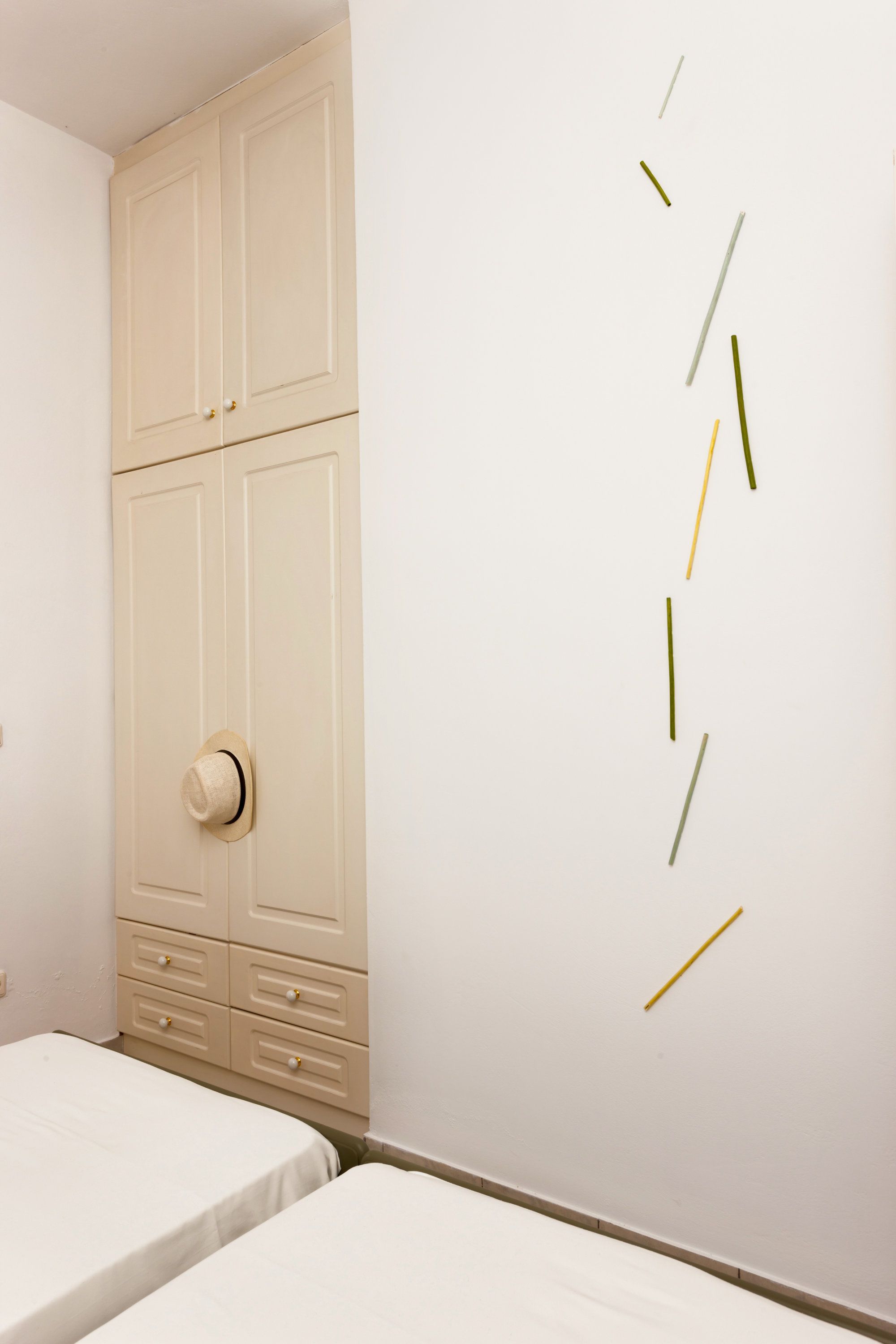 Un dormitorio con cama, armario y una pared decorada con arte abstracto.
