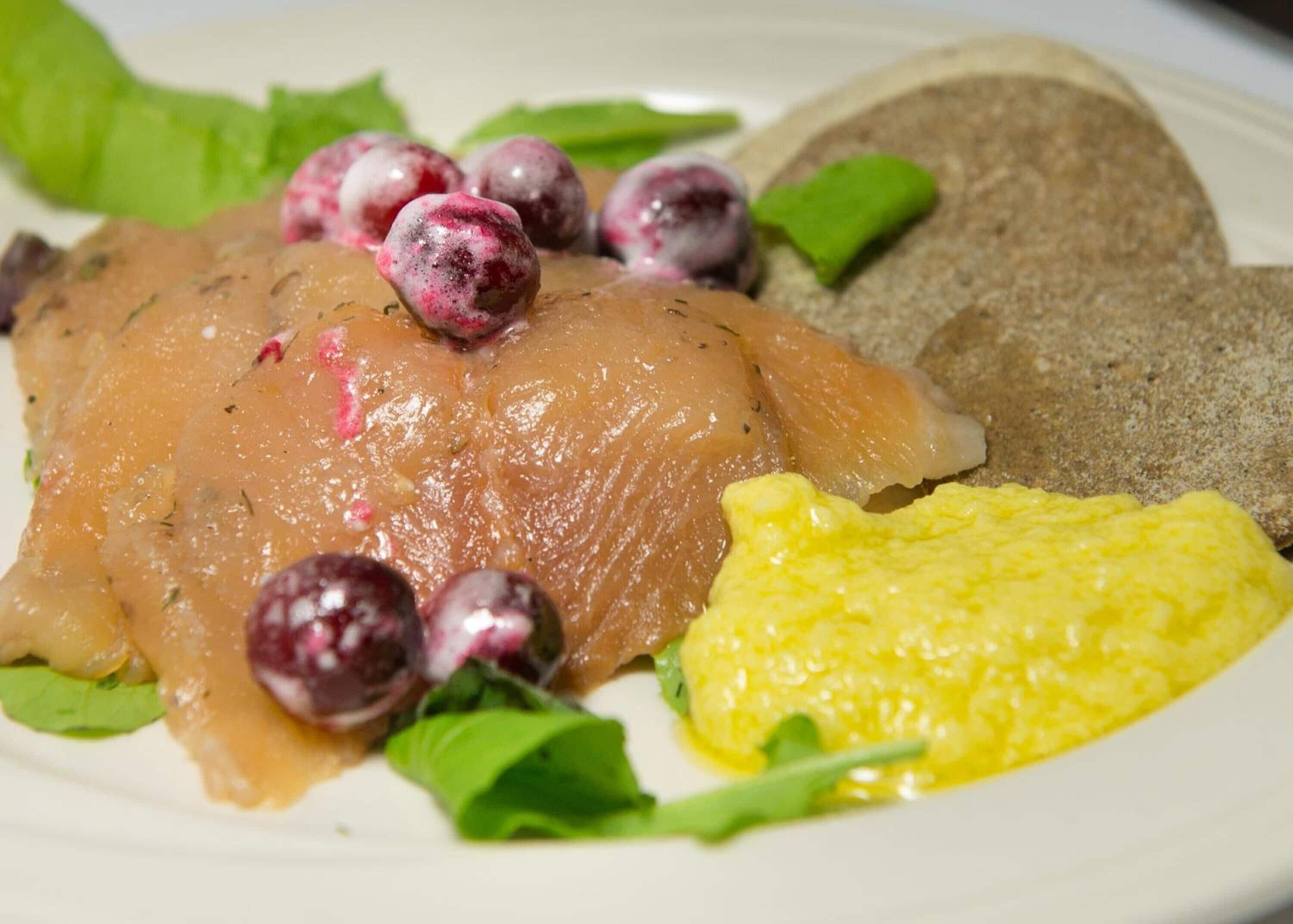 Ein Teller mit Lachs, Rührei und Beeren.