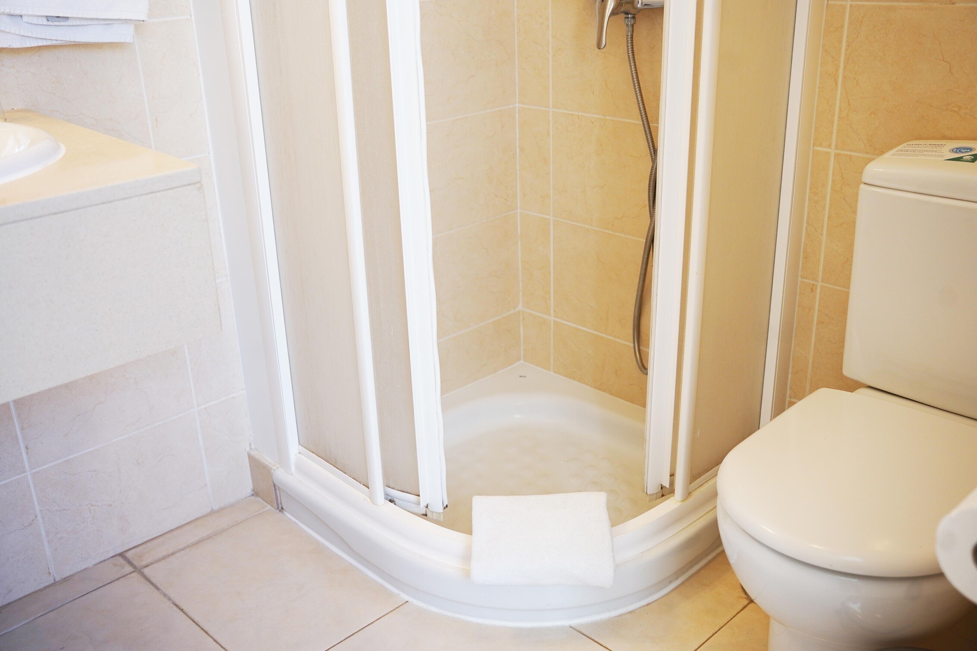 Un bagno con doccia, WC e lavandino.